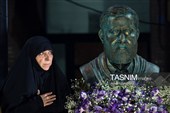سعیده سالاری، همسر سردار شهید  محمدسعید ایزدی (حاج رمضان) در کنار سردیس این شهید